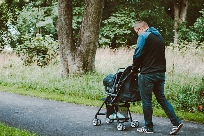 Man pushing baby stroller outdoors symbolizing family and cheating stories