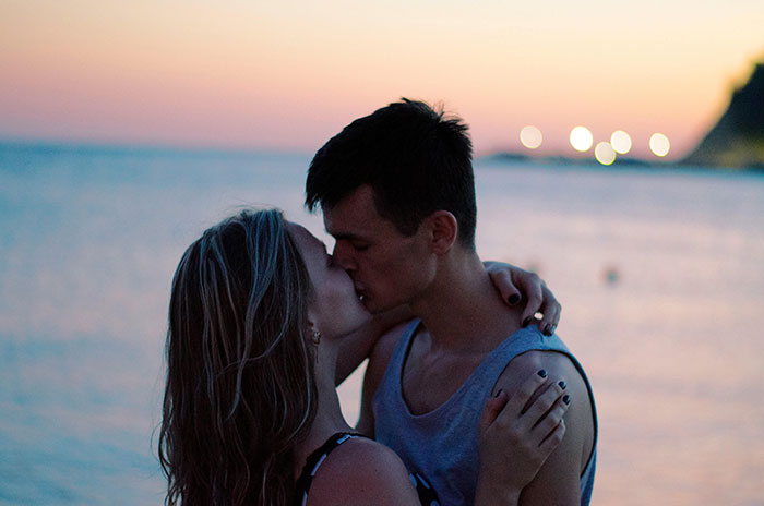 Couple kissing at sunset reflecting emotional moments from cheating stories