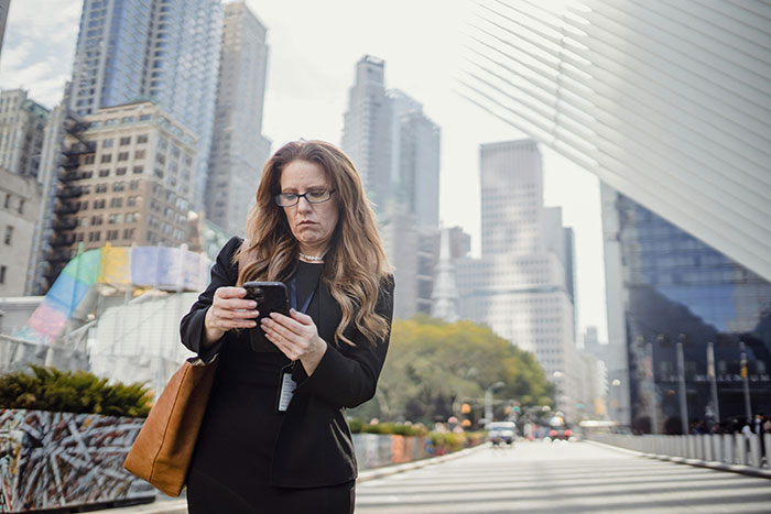 Woman looking upset at phone in cityscape representing cheating stories