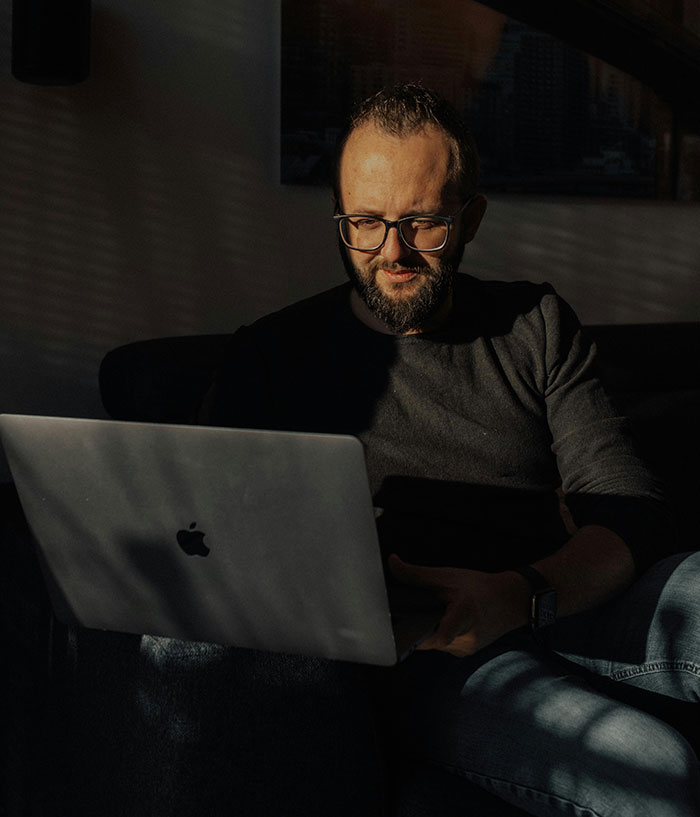 Man using laptop in dim light about ugly cheating stories