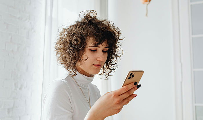 Woman reading message on phone about ugly cheating stories and truth