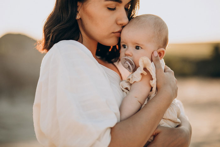 Mother tenderly holding baby reflecting paternity test situation Mother tenderly holding baby reflecting paternity test situation