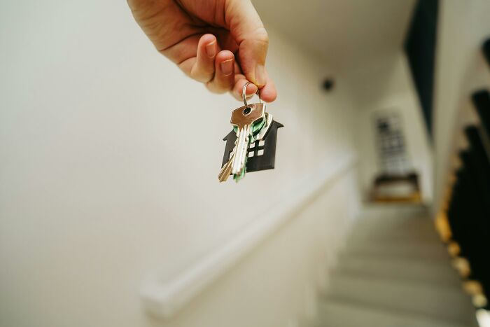 Hand holding house key with blurred background scared staying home alone