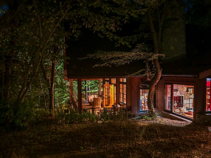 Cozy illuminated house at night surrounded by trees scared staying home alone