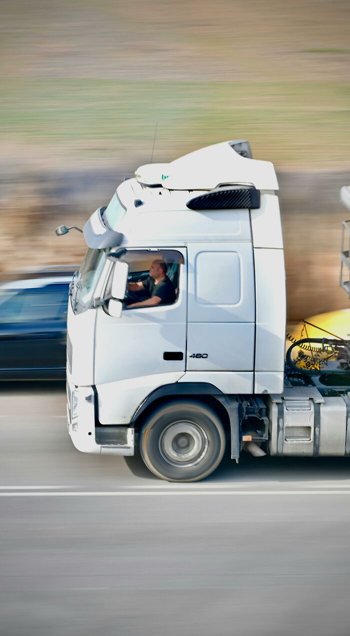 A white truck speeding on a highway next to a blue car. Could this be one of the very creepy things experienced?