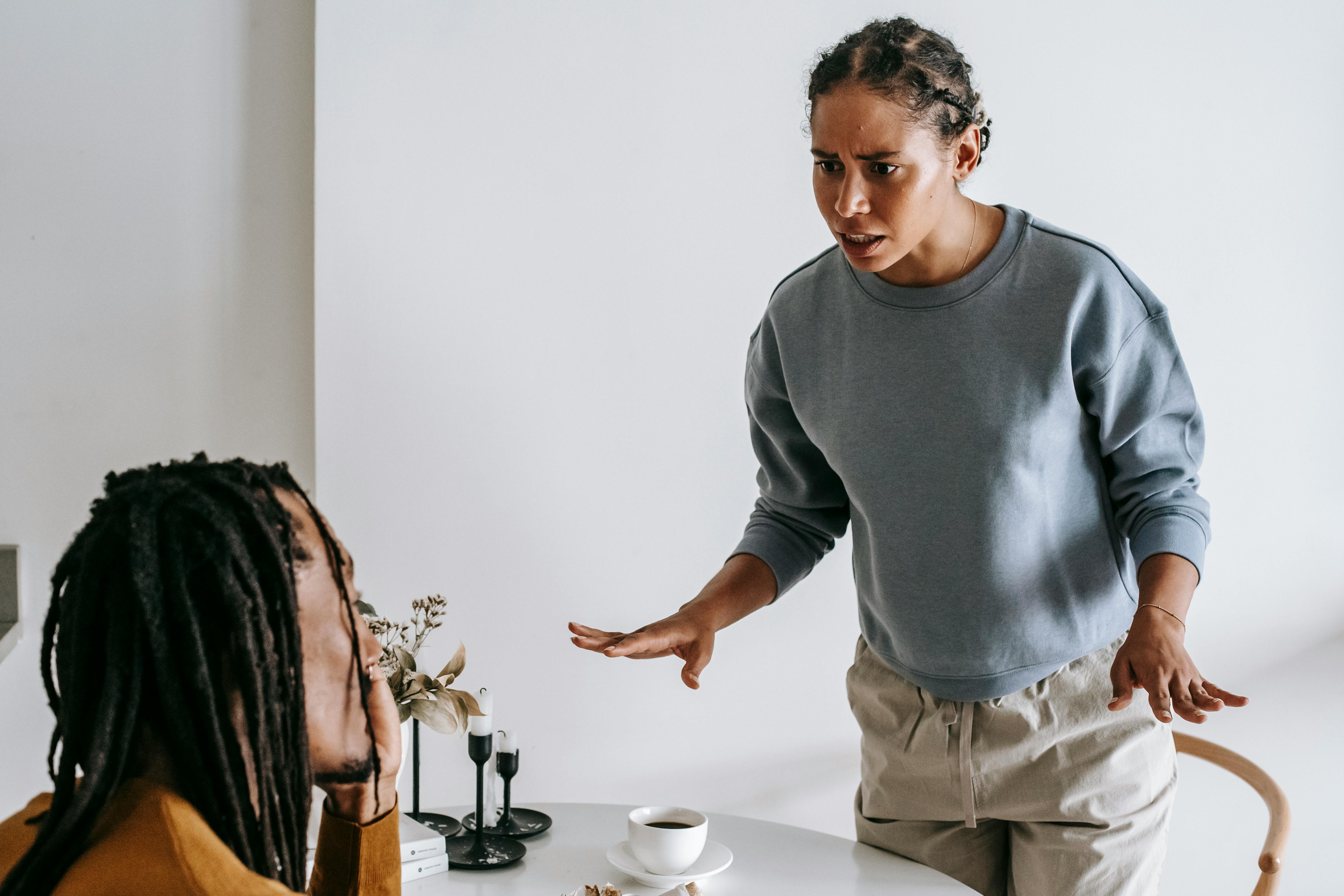 Angry woman confronting husband about his friends behavior indoors