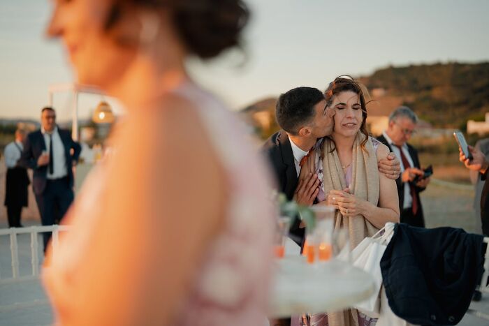Man kissing woman on cheek at emotional moment during wedding