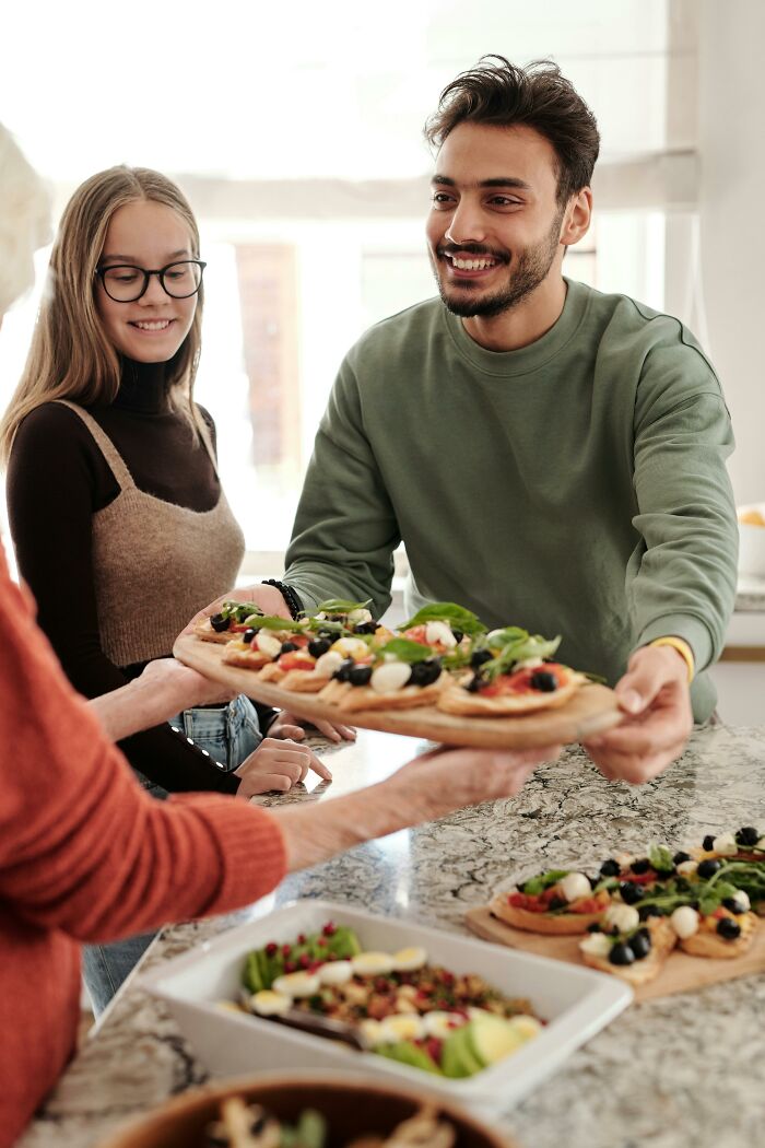 Group sharing homemade vegetable and cheese pizzas embracing frugal dining