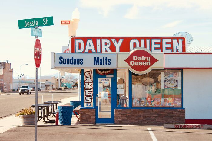 Dairy Queen storefront at street corner with sundae and malt signage