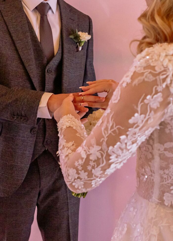 Bride putting wedding ring on groom's finger