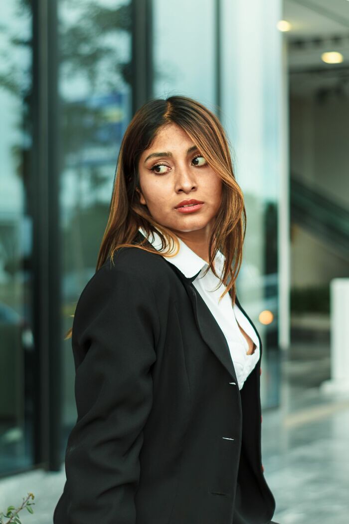Woman in blazer looking away outside a courtroom building