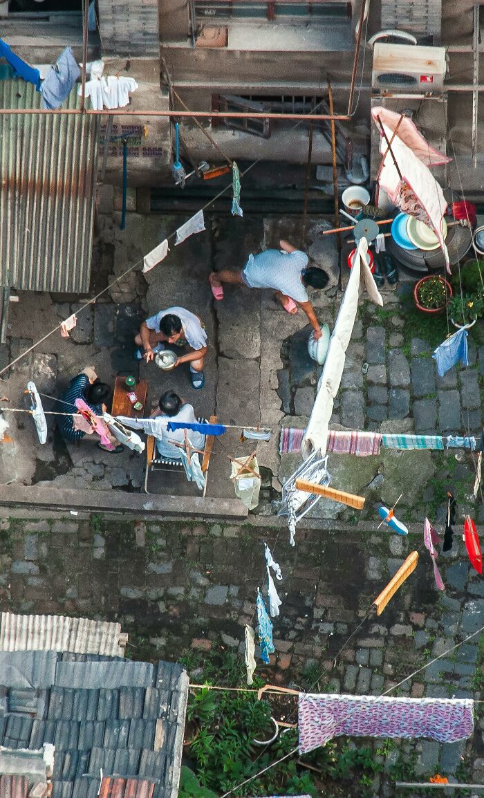 Overhead view of neighbors from hell courtyard with clotheslines and people gathered outside