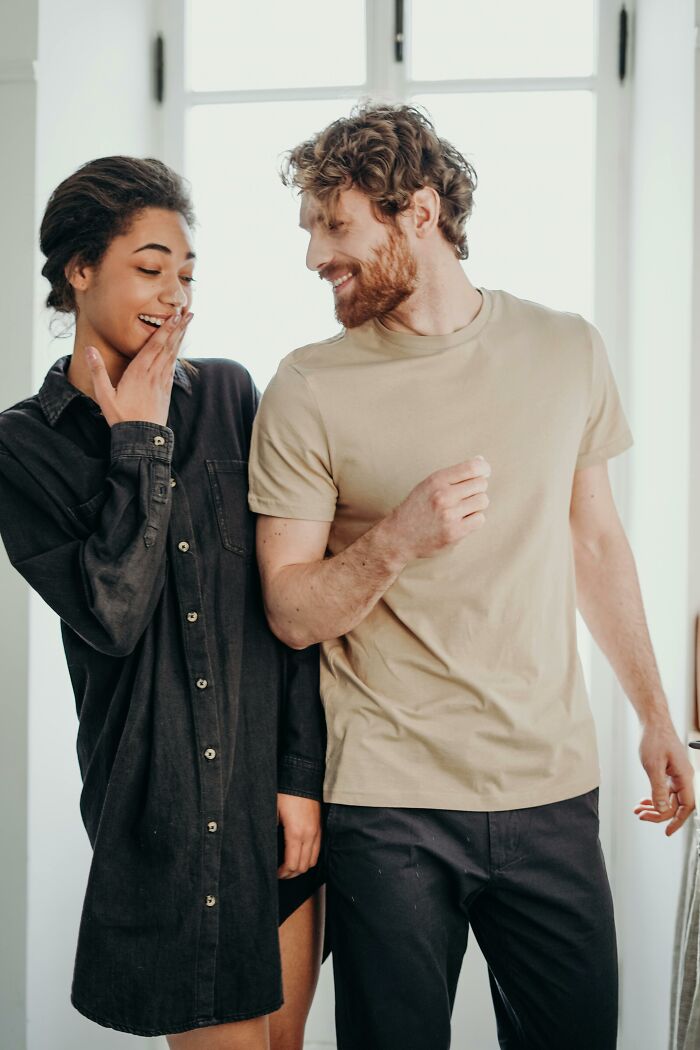 Couple smiling and dancing inside, capturing joyful connection of long term partners