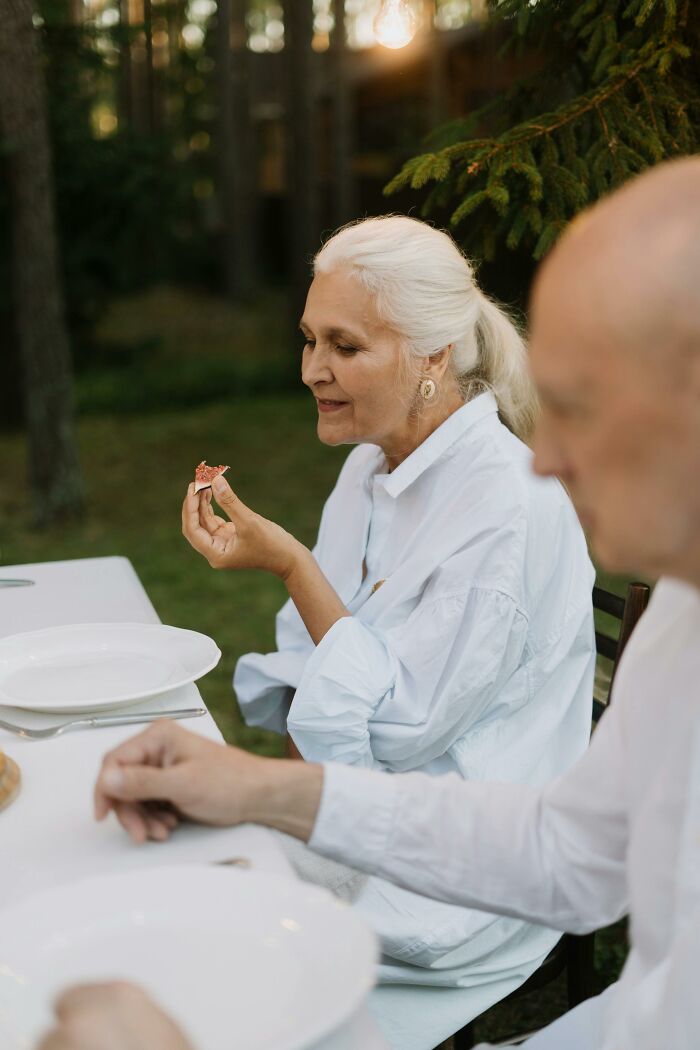 Senior woman enjoying frugal meal outdoors with a small food portion
