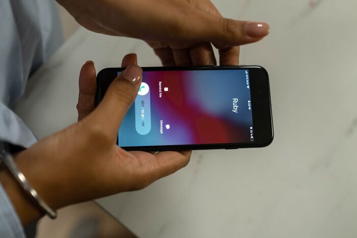 Woman holding phone showing incoming call from Ruby at wedding