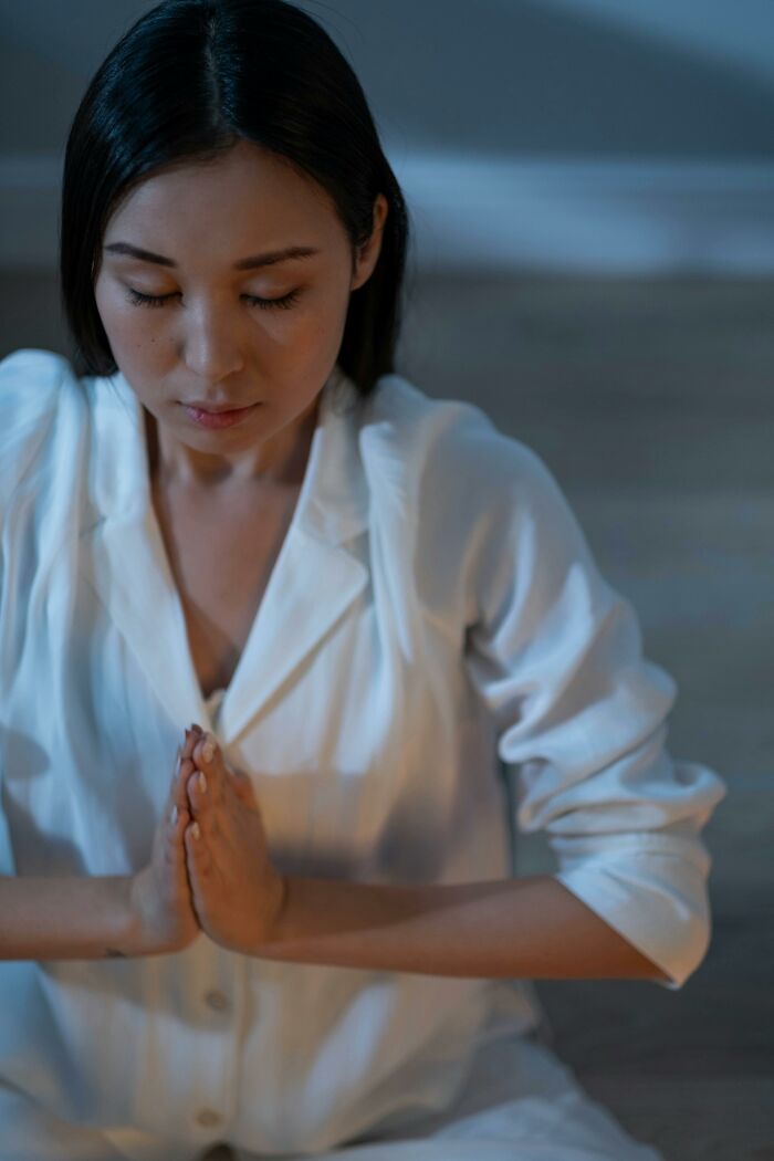Woman meditating and praying in quiet calm setting