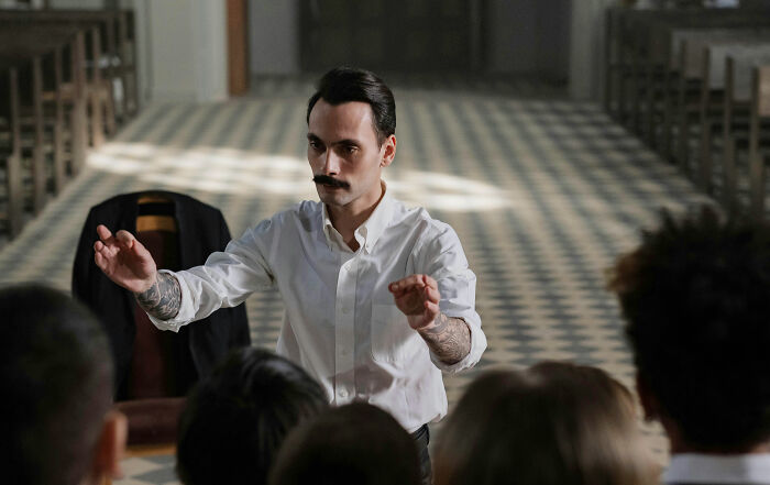 Man leading a cult meeting with followers in a church