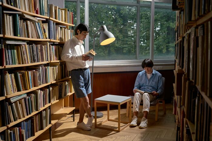 Two young men reading books in a quiet library for philosophy knowledge Two young men reading books in a quiet library for philosophy knowledge