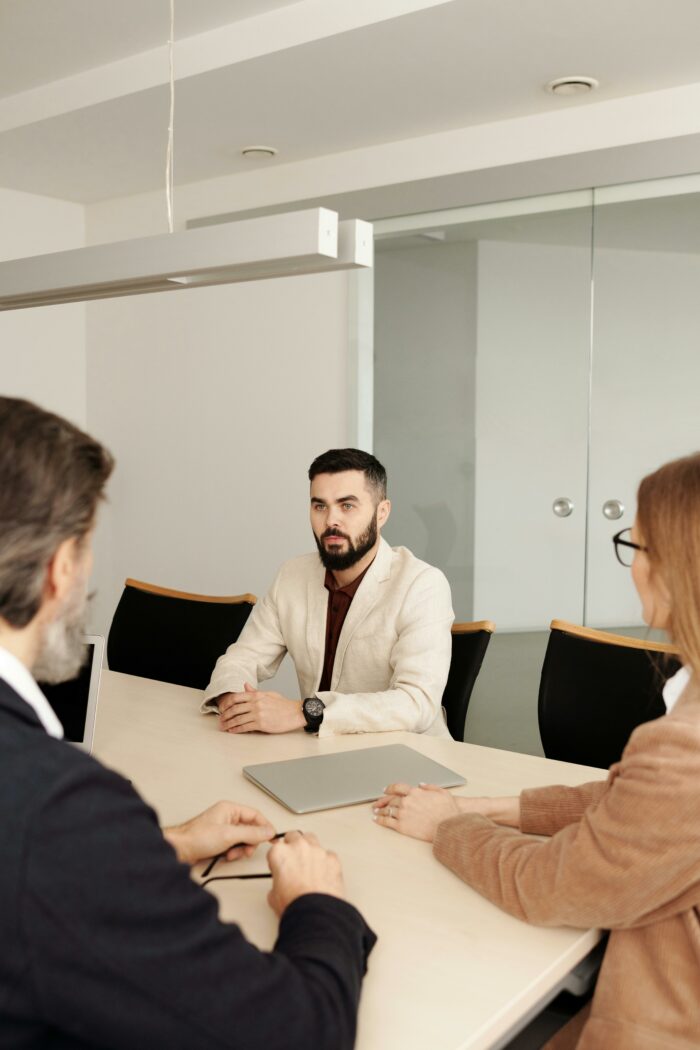 Man attending a job interview with two interviewers at modern office table Man attending a job interview with two interviewers at modern office table