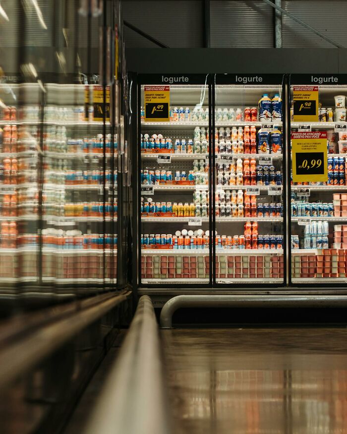 Rows of yogurt and drinks in a refrigerated display case at a store, reflecting disturbing d***h stories.