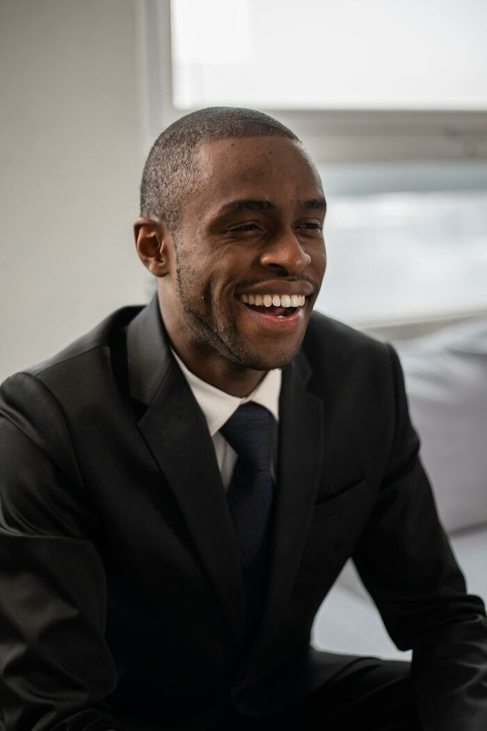 Smiling man in suit laughing during courtroom story session