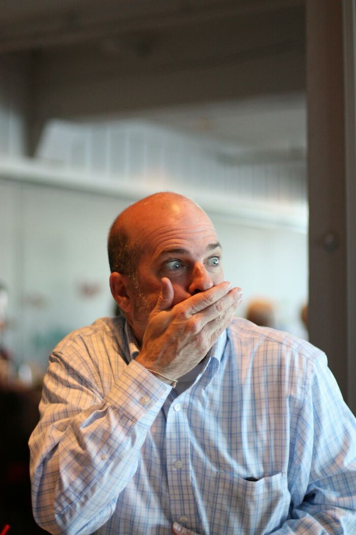 Surprised man covering mouth, symbolizing laziness avoiding disaster