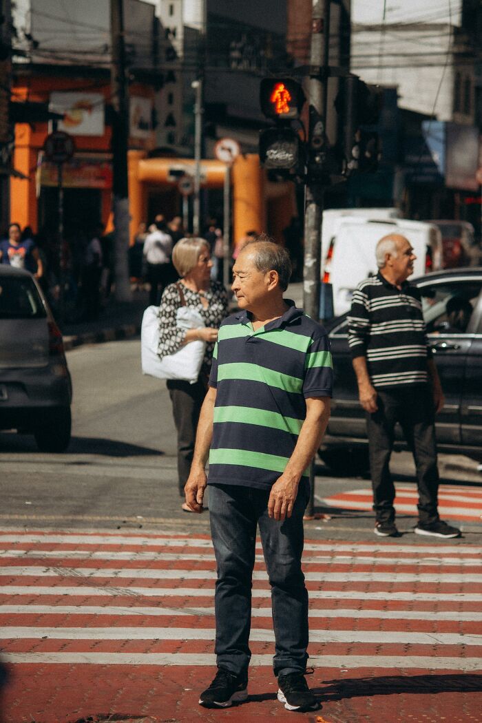 Man standing on crosswalk waiting for green pedestrian signal