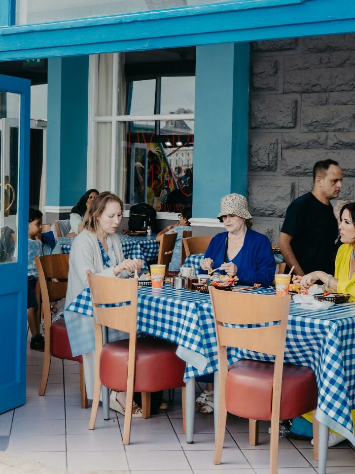 People sitting at a restaurant with blue checkered tablecloths