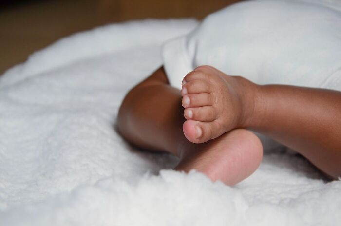 Close-up of baby feet wrapped in a soft white blanket