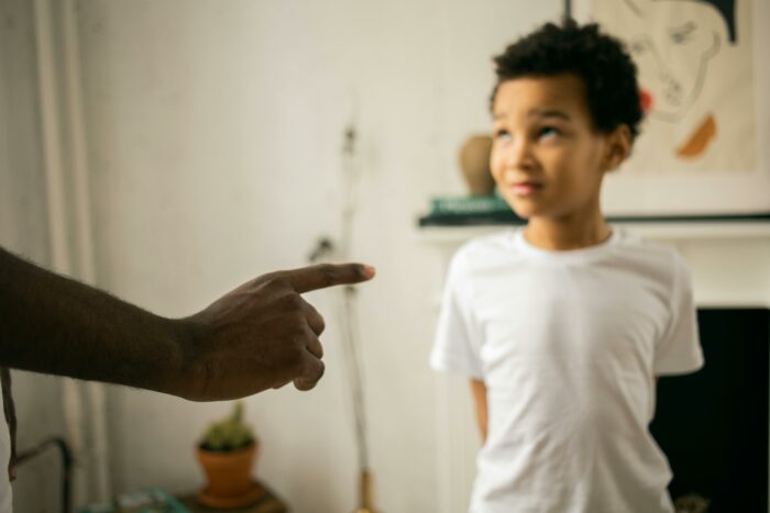 Adult finger pointing at child in disagreement