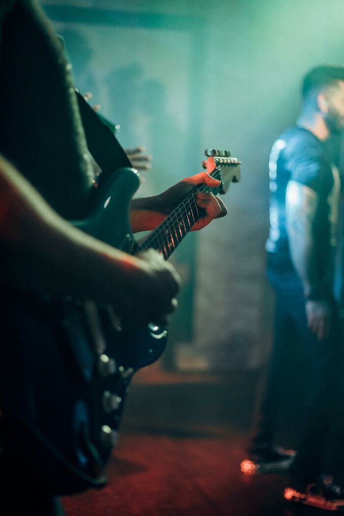 Musician playing electric guitar in a cult-related concert or gathering
