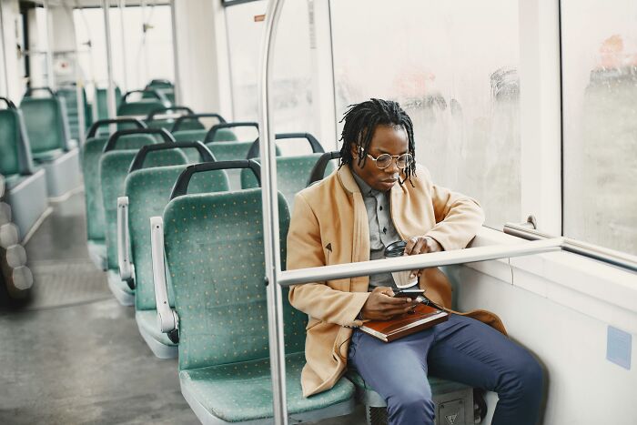 Man sitting alone on bus looking at phone weird confessions