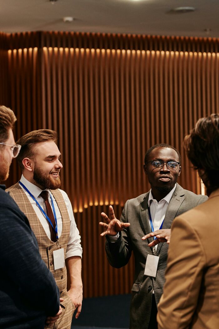 Group of men laughing and talking at a conference with badges