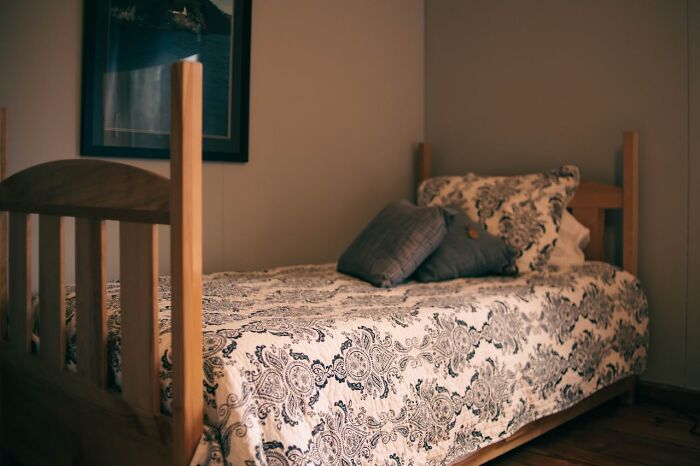 Cozy wooden bed with patterned bedding symbolizing comfort and random facts