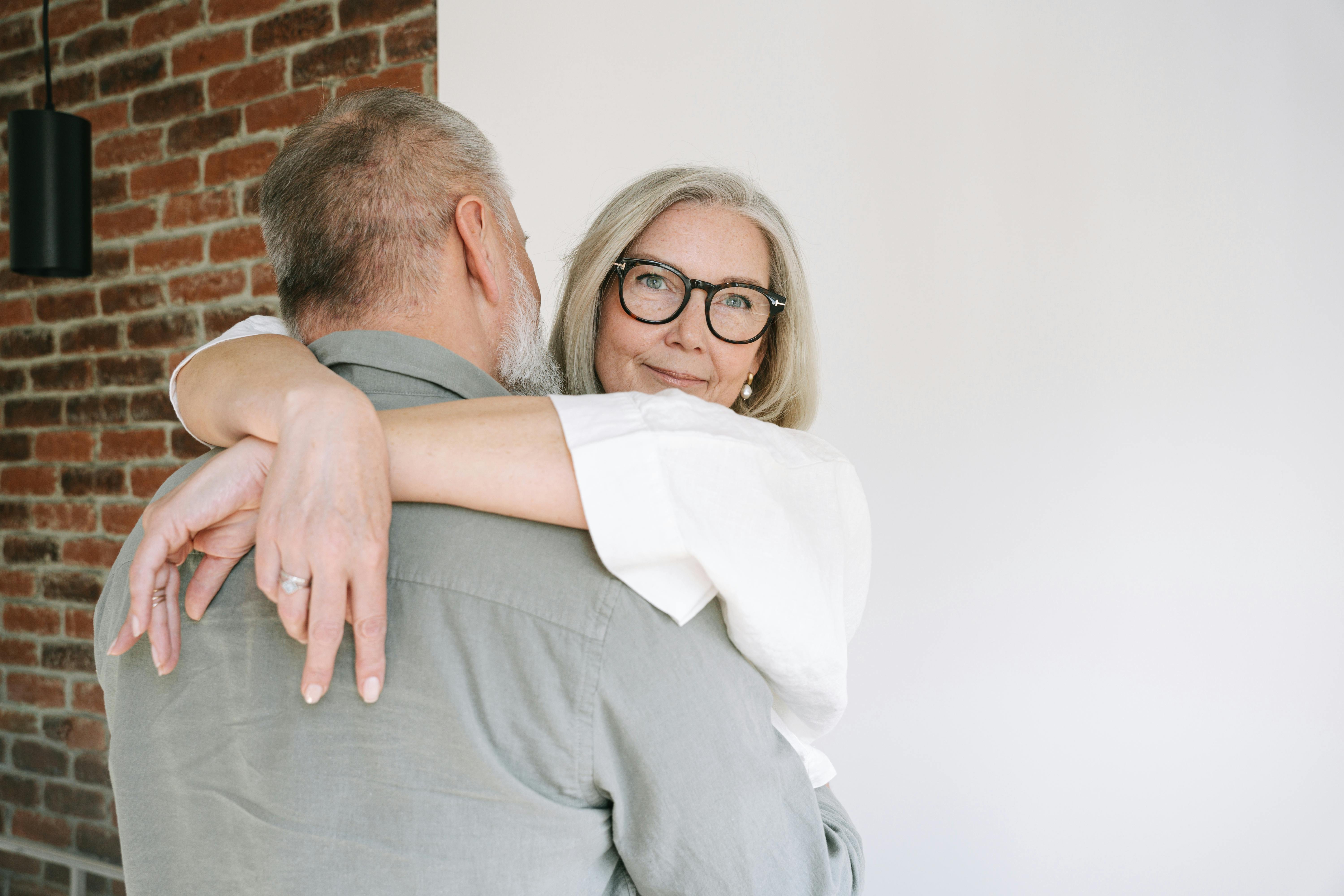 Older woman hugging a man with focus on mother-in-law support