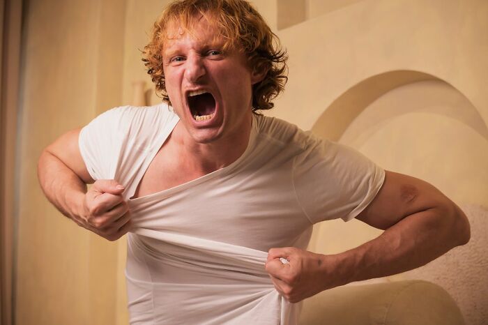 Angry man tearing his white shirt in a heated courtroom story scene