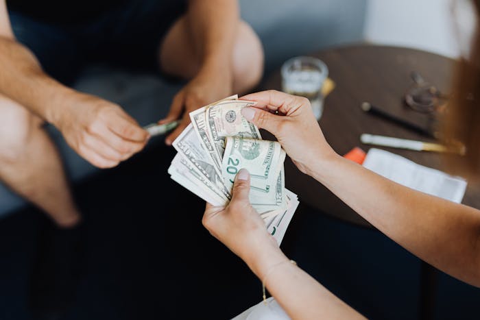 Hands exchanging cash representing inheritance money Hands exchanging cash representing inheritance money