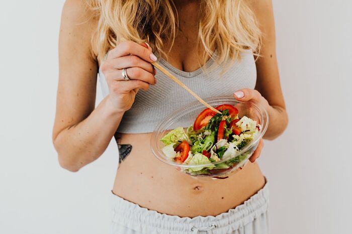 Woman holding bowl of fresh salad for healthy eating
