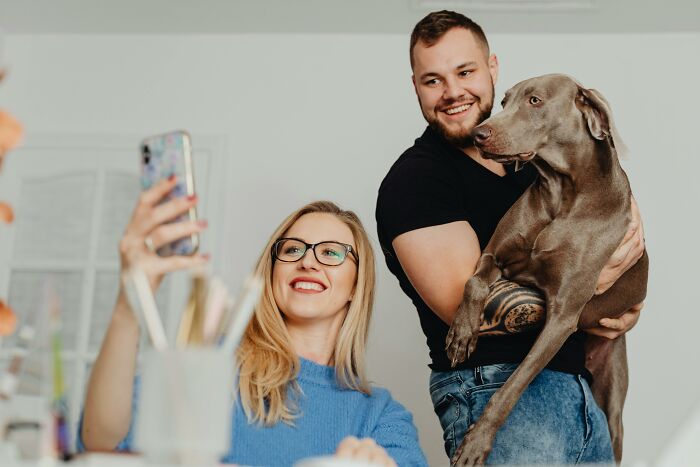 Happy couple taking selfie with dog showing joyful post-ex relationship moments