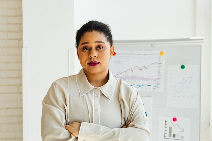 Confident woman in office with financial charts