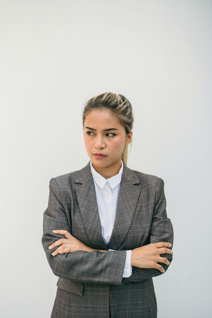 Serious woman in blazer with arms crossed for courtroom stories