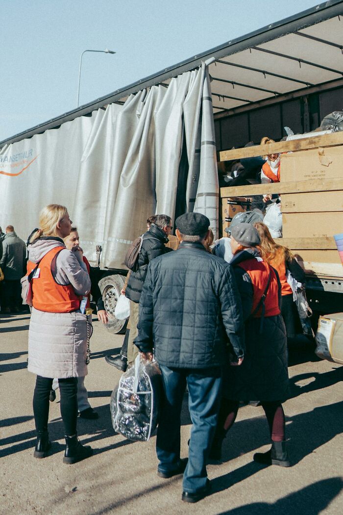 People unloading a truck with supplies outdoors during the day