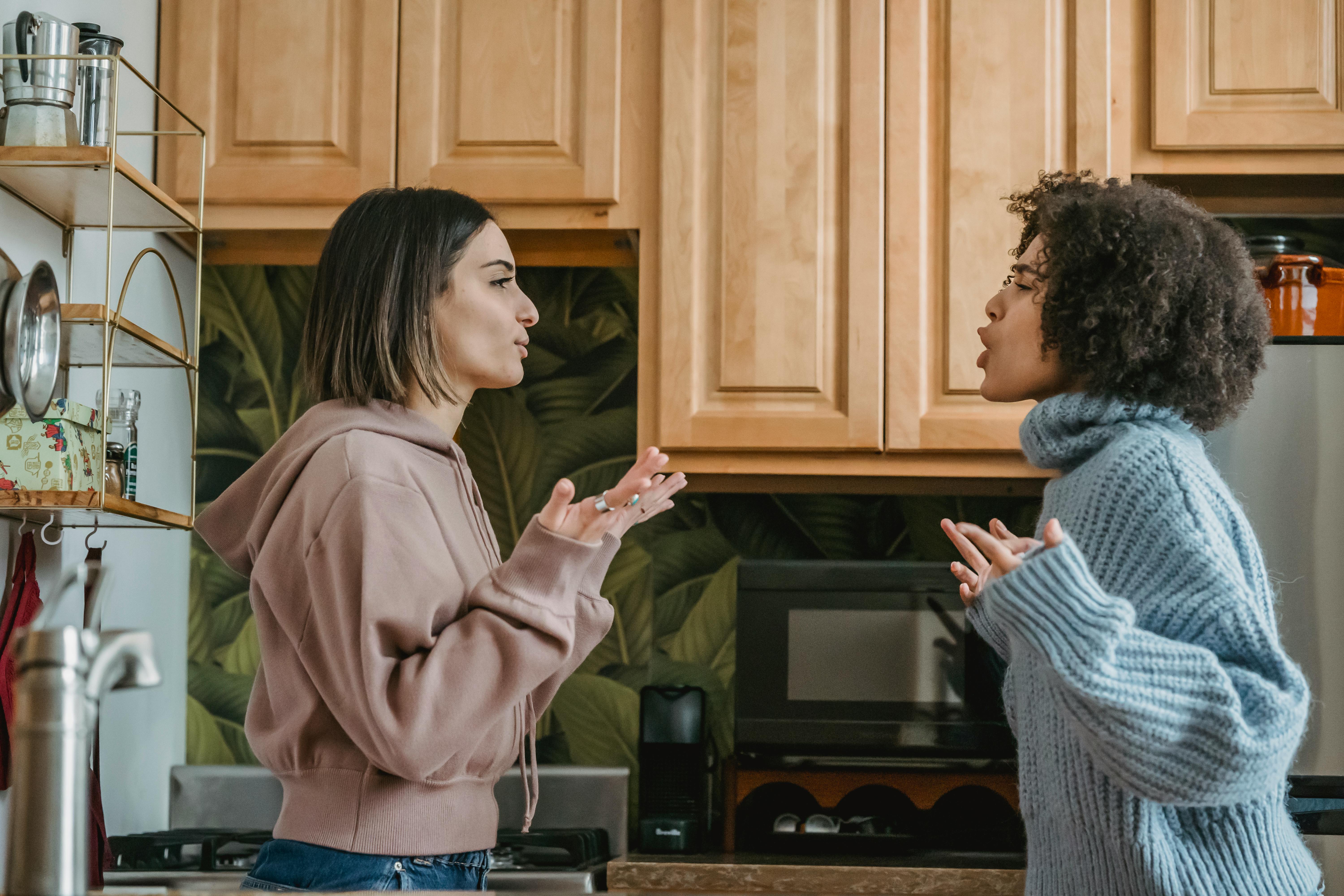 Two women having a heated argument in a kitchen about bridesmaid conflict Two women having a heated argument in a kitchen about bridesmaid conflict