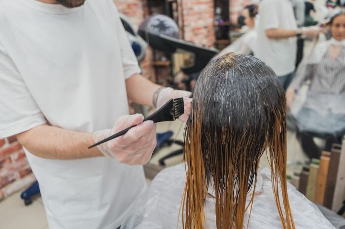 Hairdresser applying dye at salon preparing a bride for wedding