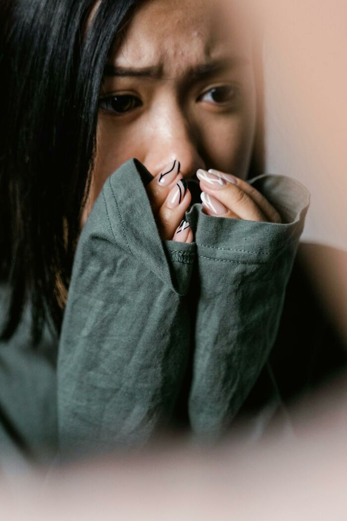 Close up of anxious woman covering face with hands showing emotional laziness