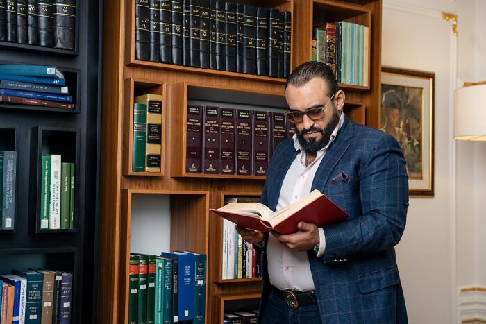 Lawyer reading a book in a library filled with legal books