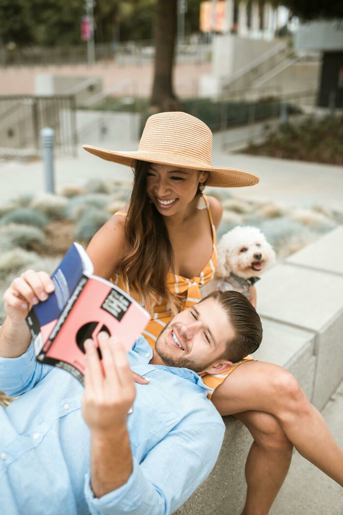 Couple reading together outside with dog, showing long term partners enjoying quality time