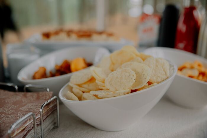 White bowl filled with chips on table highlighting frugal snack options