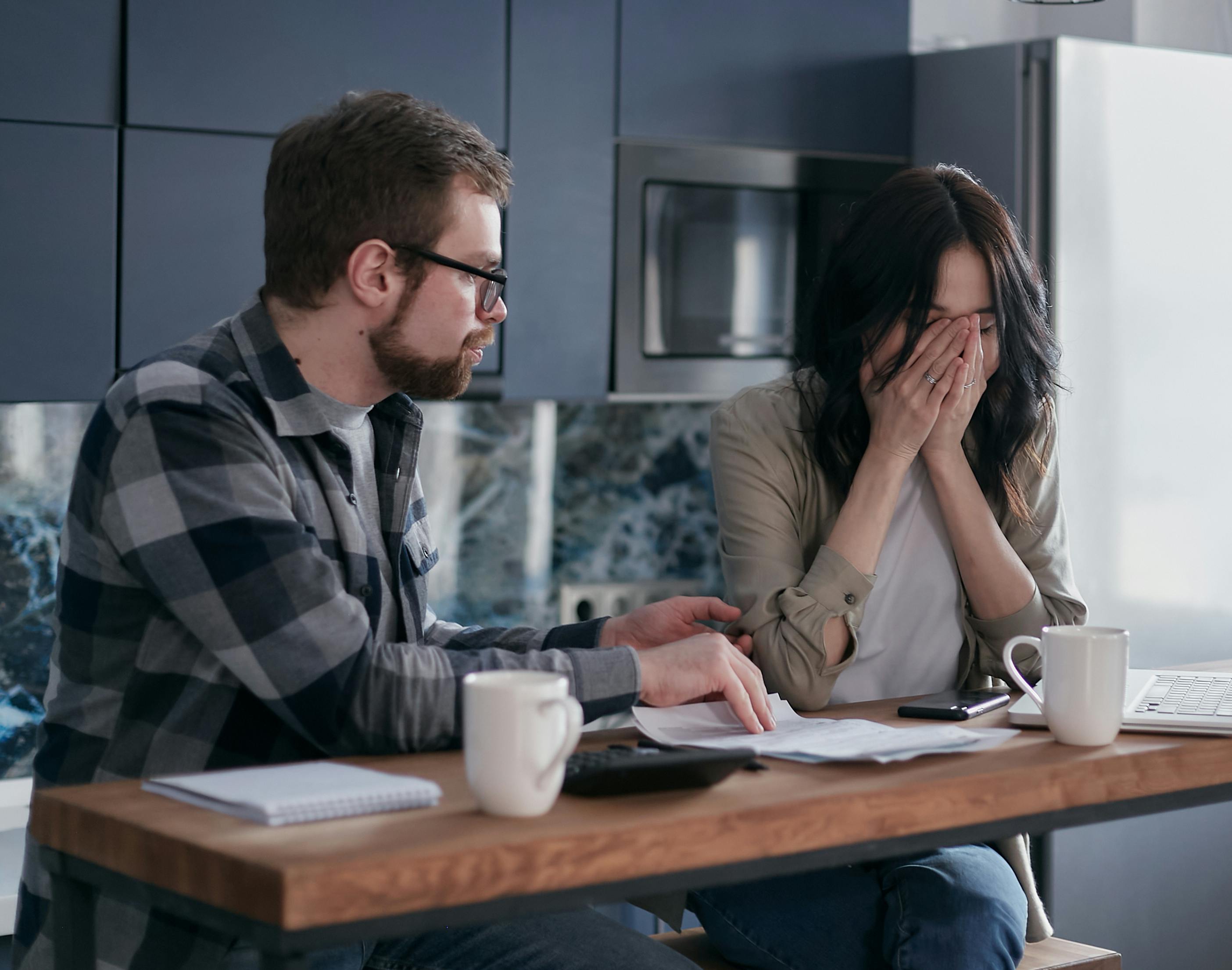 Man comforting a distressed woman in kitchen setting