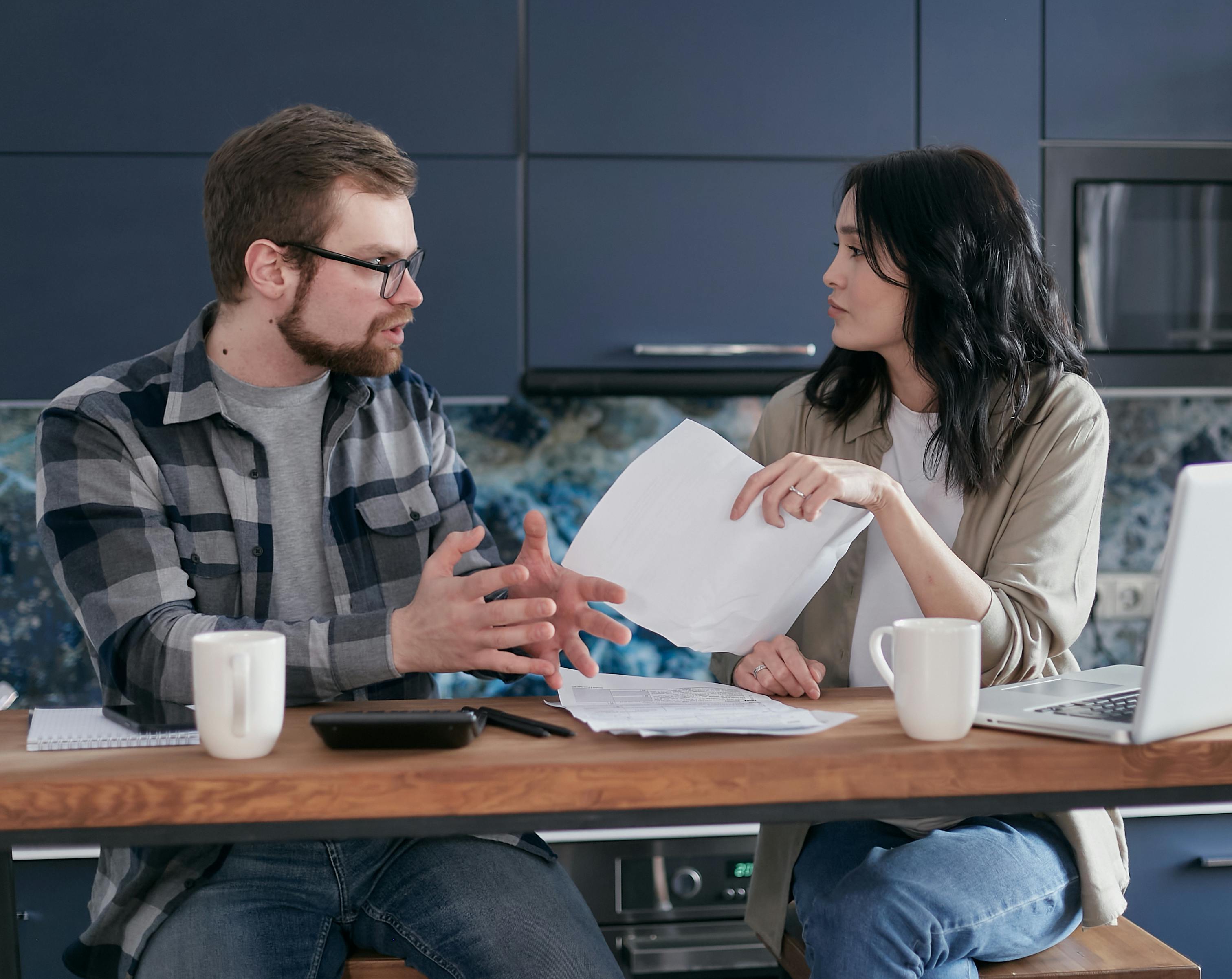 Couple debating finances and prenup agreement at home